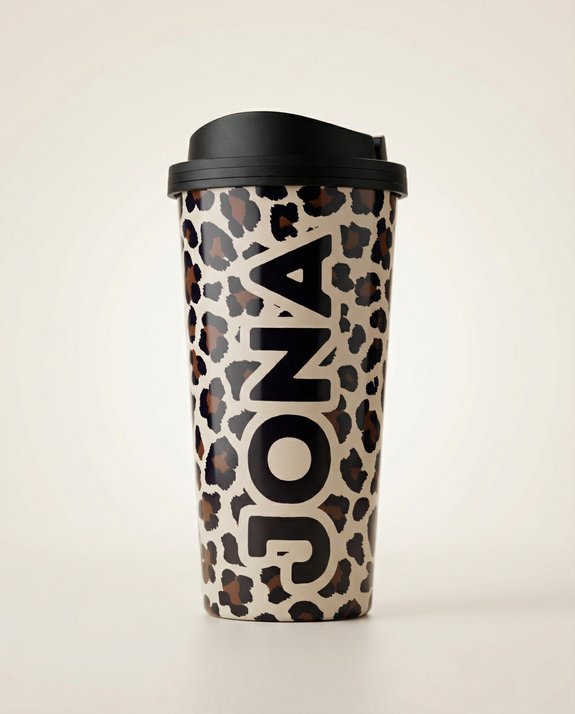 Leopard print travel mug with black lid on a light beige background